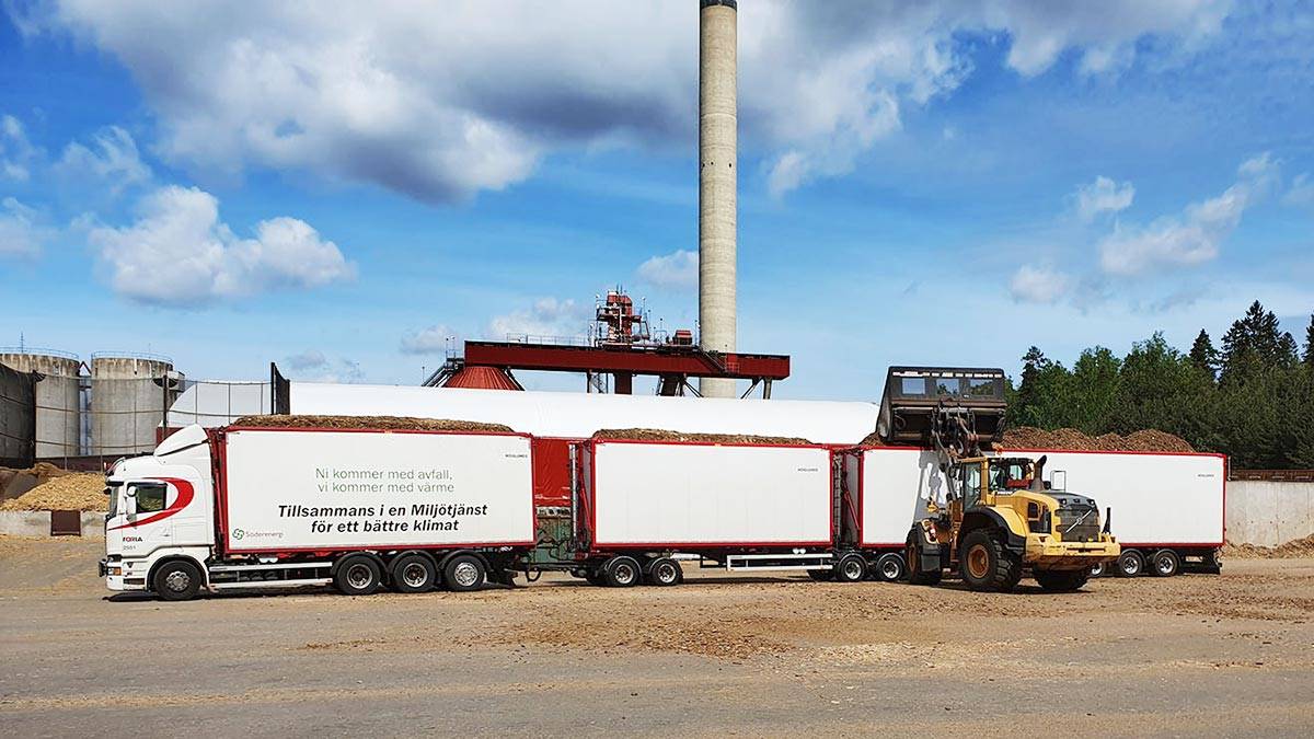 A big truck being filled with wood. 